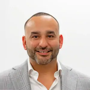Professional businessman smiling in a gray suit for business success and finance growth.
