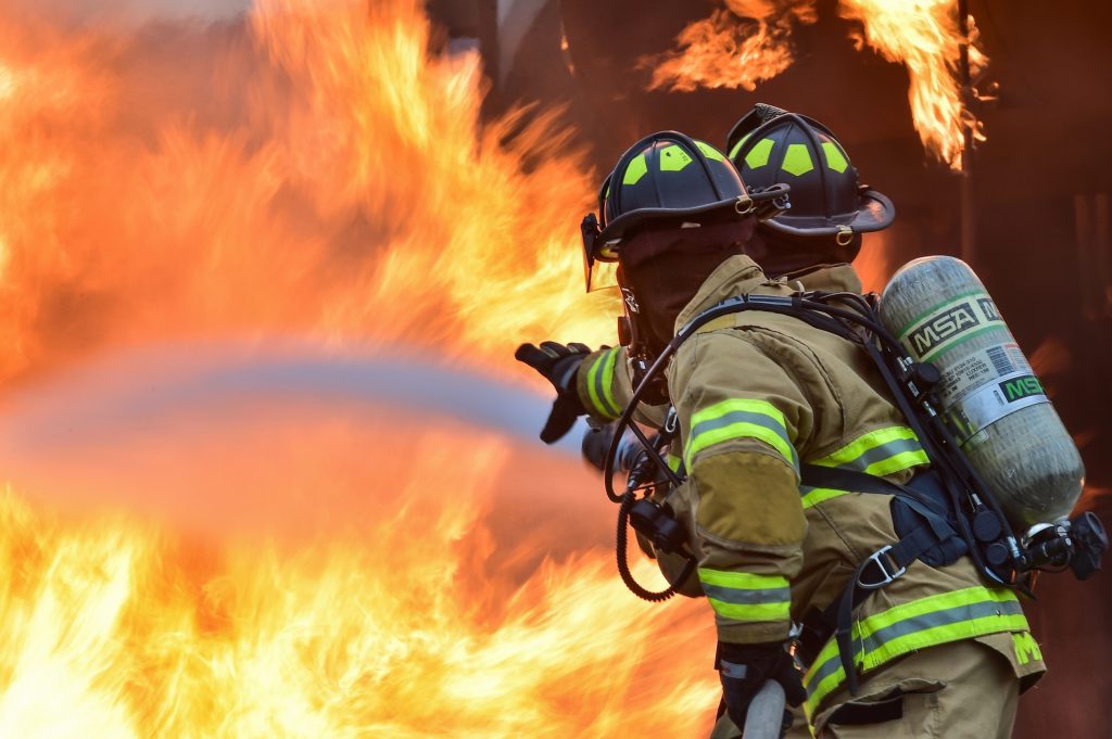 Firefighters putting out a fire for a business that has small business insurance