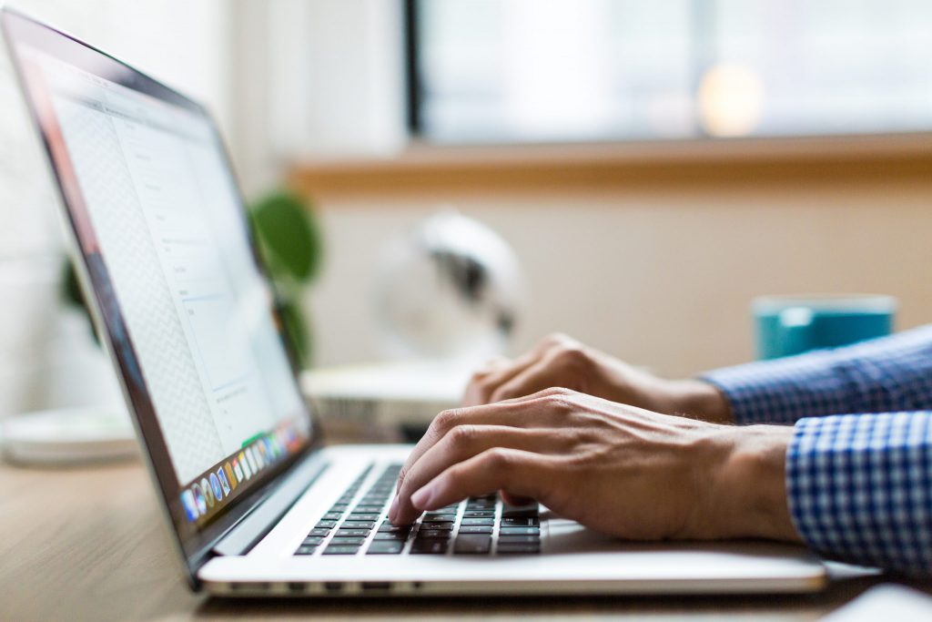 A business owner writing a business proposal with their laptop