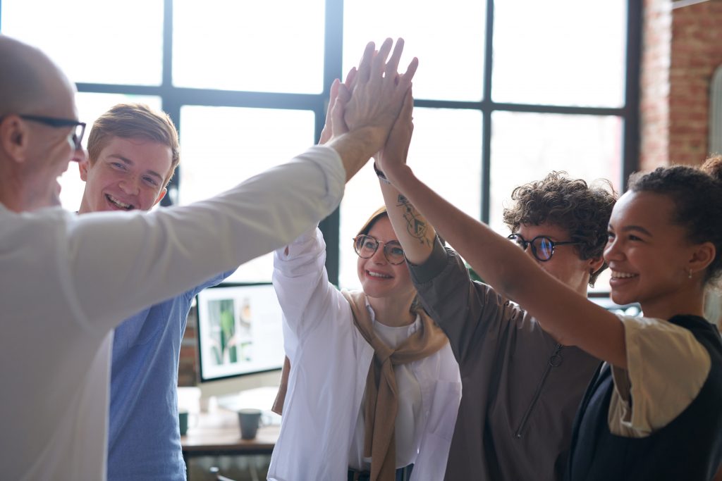 A team of employees giving hi five's because they won't give up to covid-19