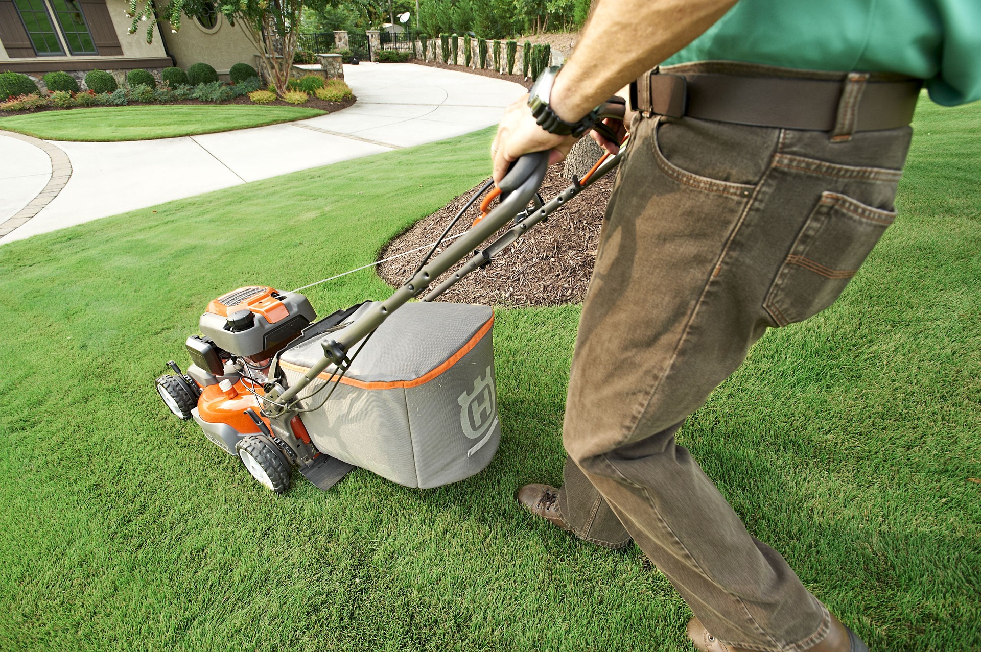 Landscaper mowing the lawn with a lawn mower purchased with equipment financing.