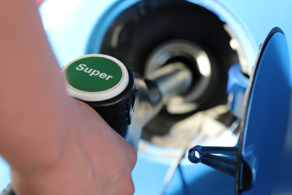 A hand pumping gas at a station that got a small business loan for gas stations