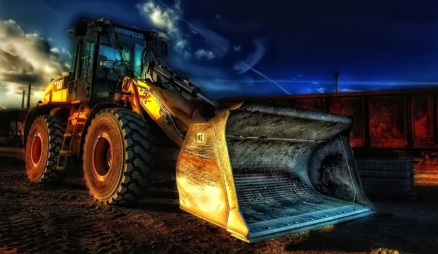 Dramatic photo of a yellow wheel loader with a large bucket under a dark sky, introducing Amur Equipment Finance