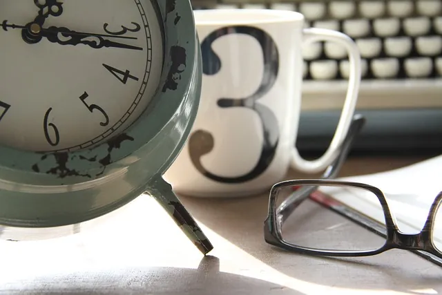 Vintage alarm clock, a mug with the number 3 and reading glasses beside a typewriter, illustrating ERTC deadline questions
