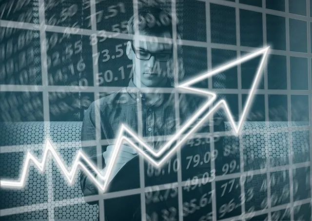 Man in glasses reading a document behind a stock ticker grid and rising arrow, closing thoughts on the ERTC deadline
