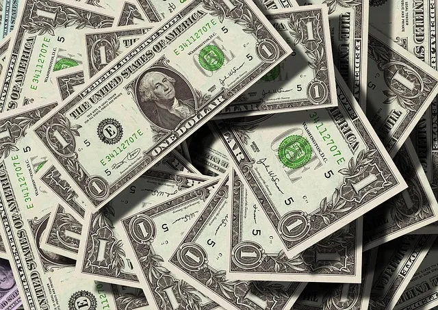 Pile of scattered US one dollar bills, representing qualifying wages for the employee retention tax credit in 2021