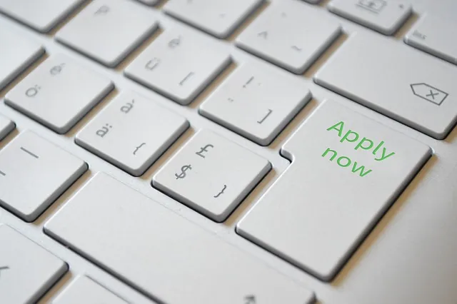 Close-up of a white keyboard with a green Apply now key, showing how to apply to Innovation Refunds